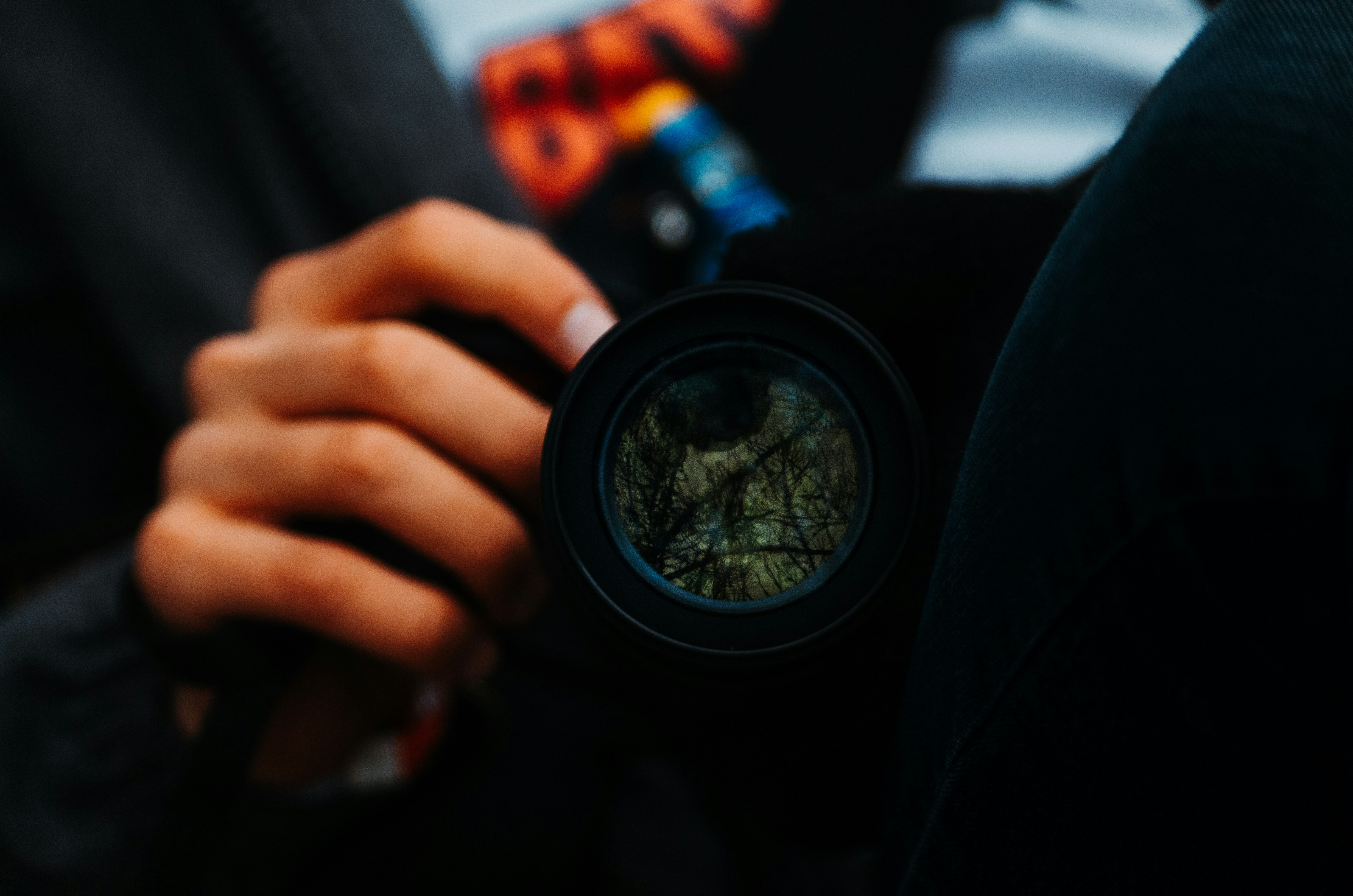 person holding black round camera lens